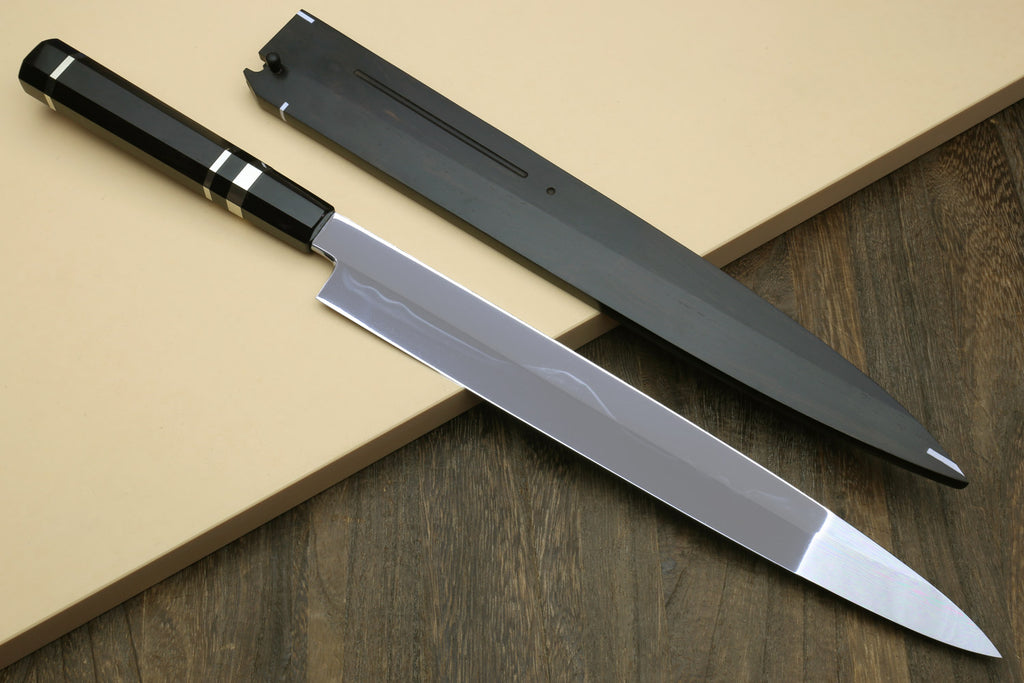 Japanese chef knife with reflective silver blade and black striped handle, side view
