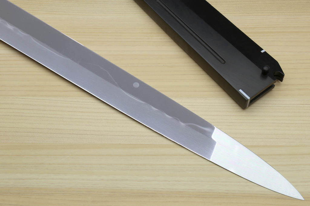 Japanese chef’s knife blade with ebony handle and silver accents, with black scabbard.