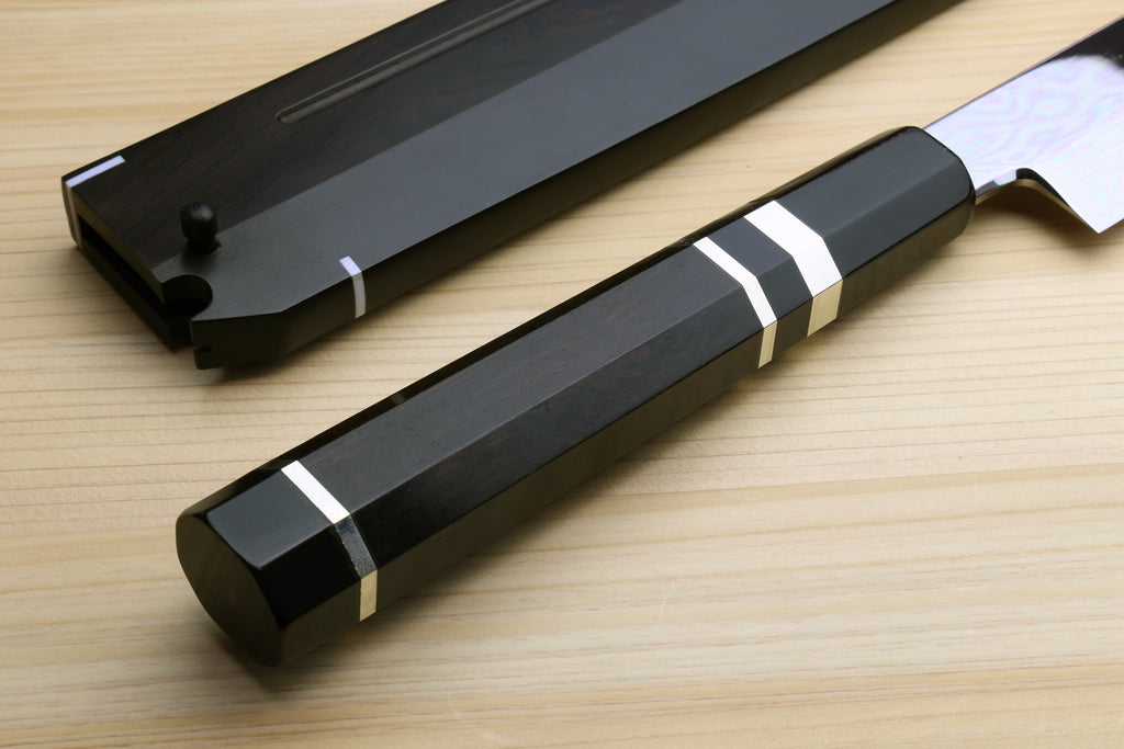 Japanese chef’s knife handle and scabbard detail, ebony finish with white-striped accents.