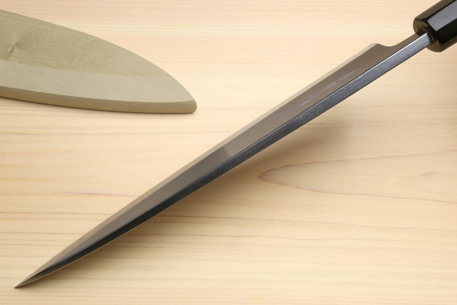 Japanese sushi and sashimi knife, silver blade with black bolster on light wood handle