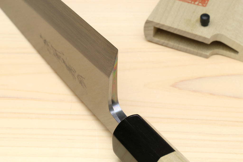 Sushi and sashimi knife close-up, silver blade bevel with black bolster and light wood handle