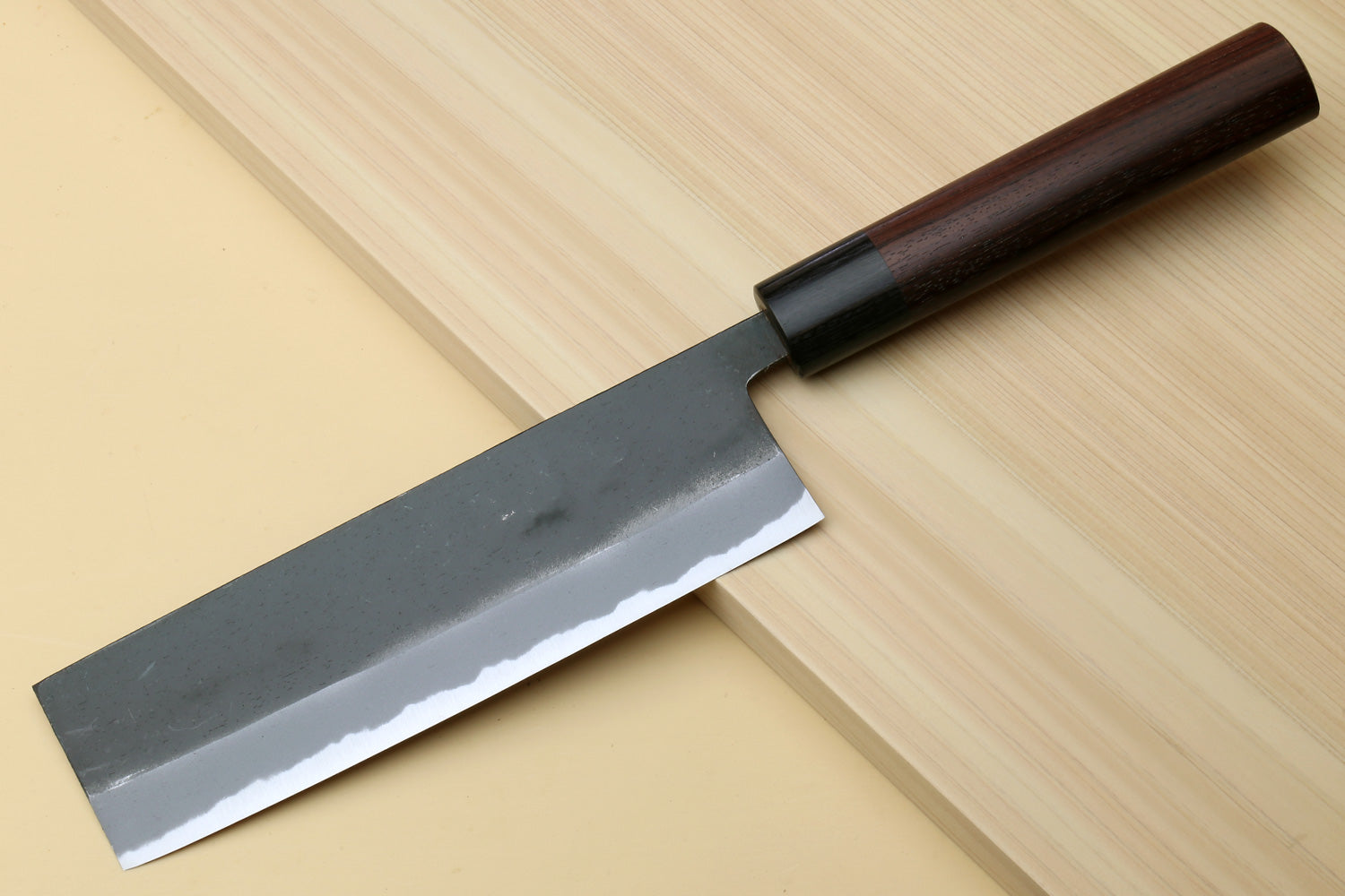 Nakiri knife blade close-up with black kurouchi finish and bright bevel edge