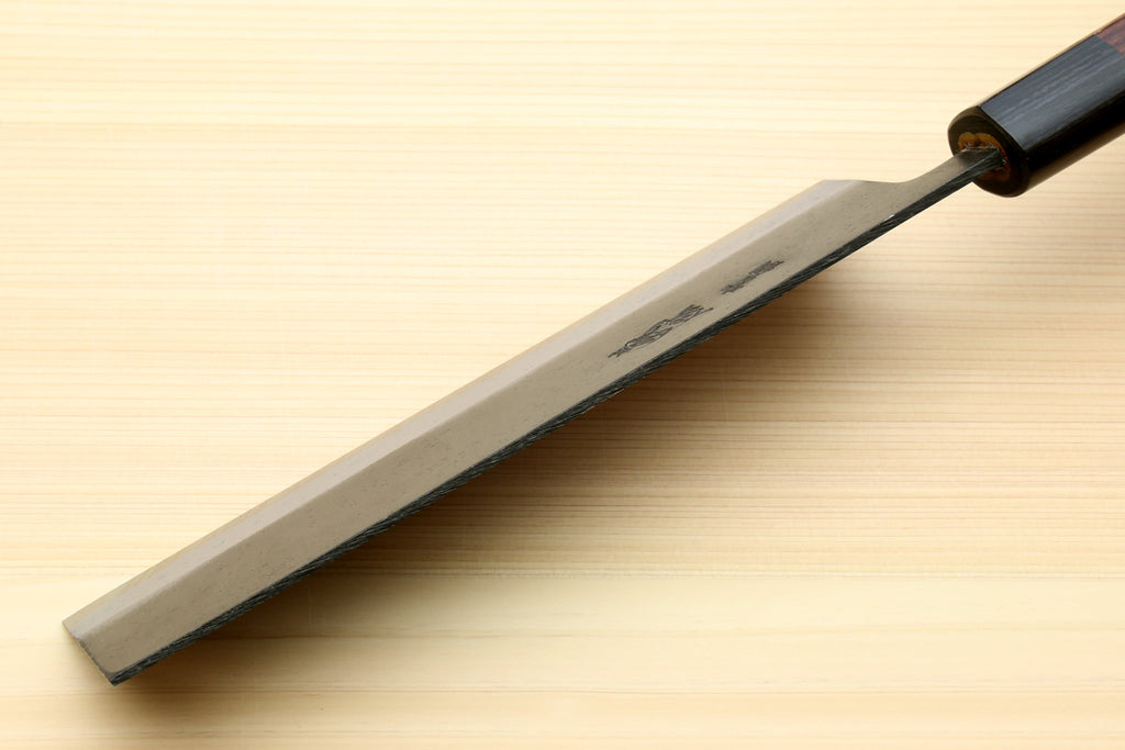 Nakiri knife side profile with flat blade edge and dark handle near the bolster