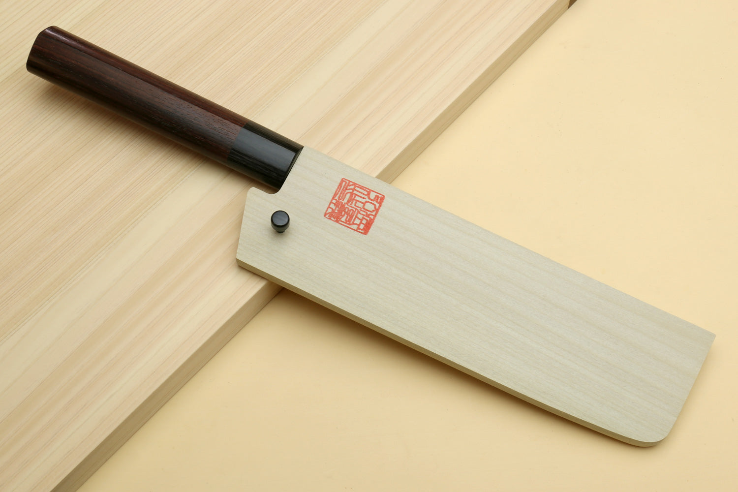 Nakiri knife with blade exposed and light wood saya cover with red seal and button