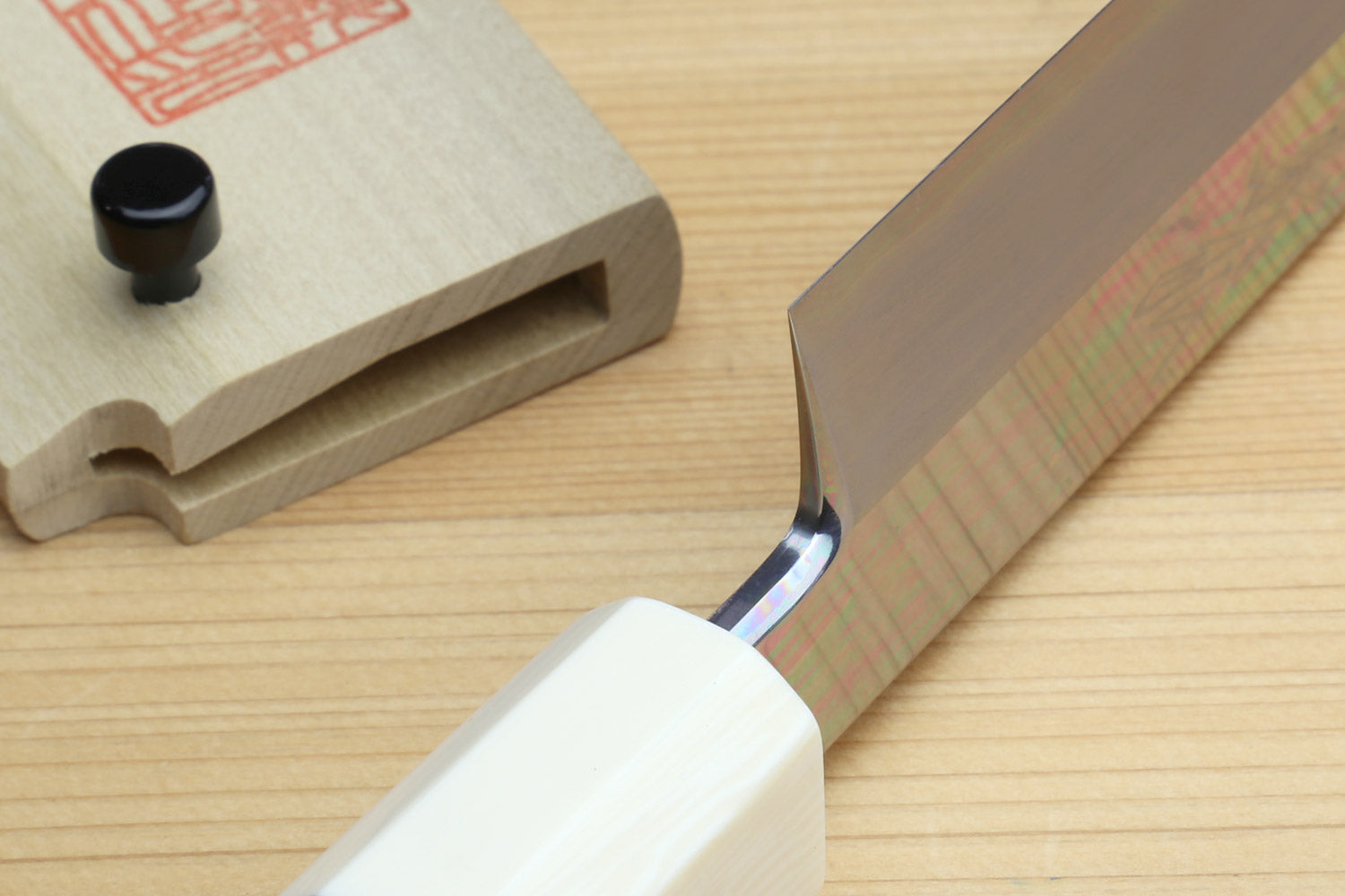 Yanagi knife detail: pale ivory octagonal handle with bolstered neck and steel blade