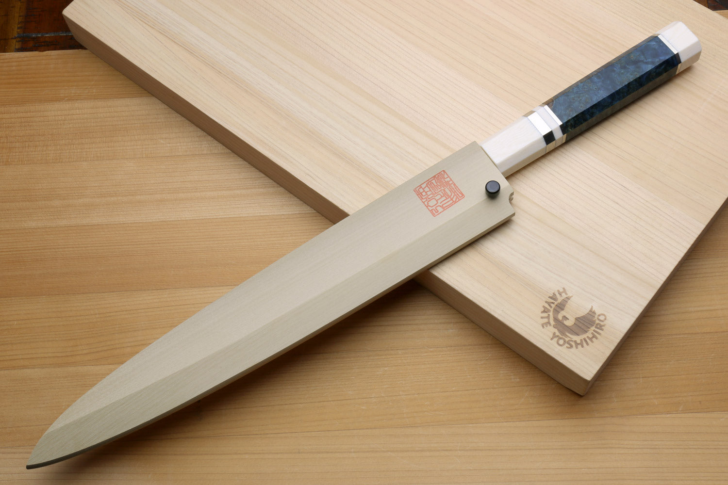 Left-handed yanagi sushi knife on wooden board: ivory handle with blue bands