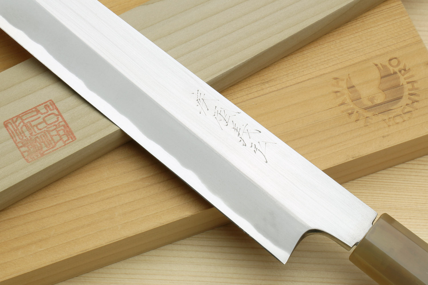 White steel yanagiba blade with etched markings and sharp edge detail