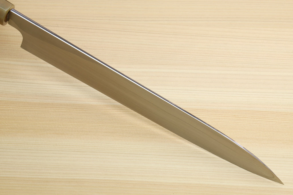 Yanagiba sushi knife blade profile on light wood surface, no handle focus