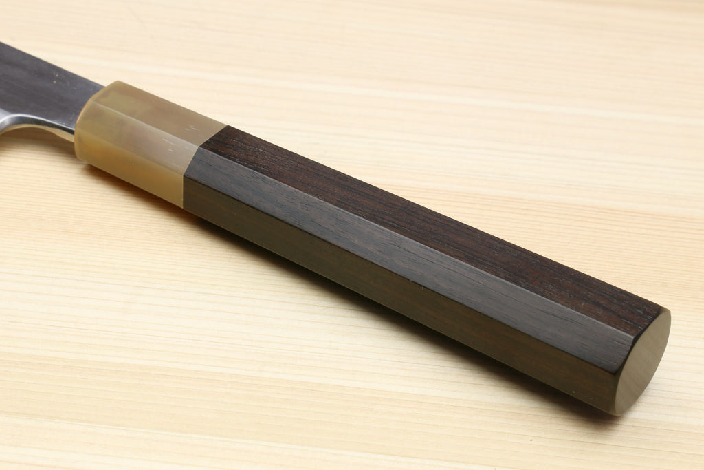 Ebony-handled yanagiba sushi knife with dark metallic blade near the spine