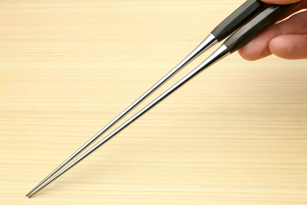 Plating tweezers with ebony handle and pointed metal tips held above a surface