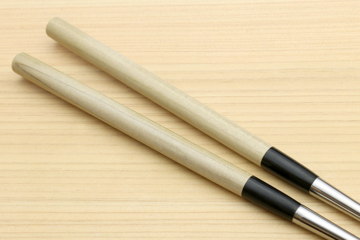 Sushi tweezers with two light wood handles and black collar, stainless tips
