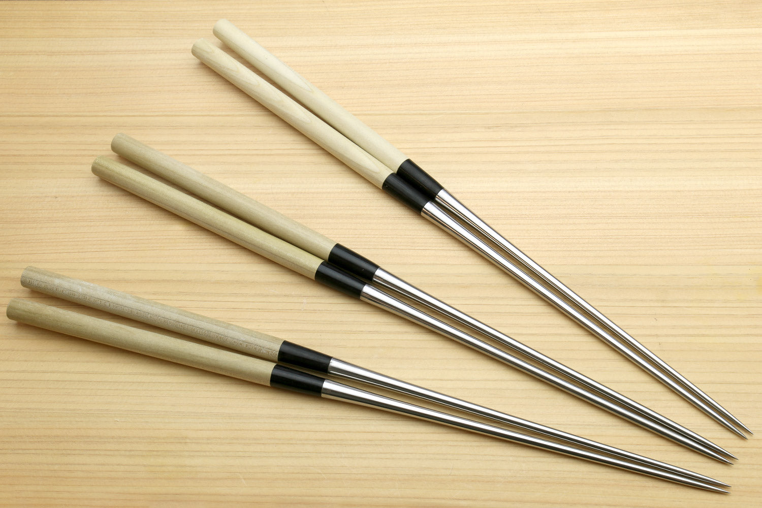 Four sushi tweezers with light wood handles and stainless steel pointed tips
