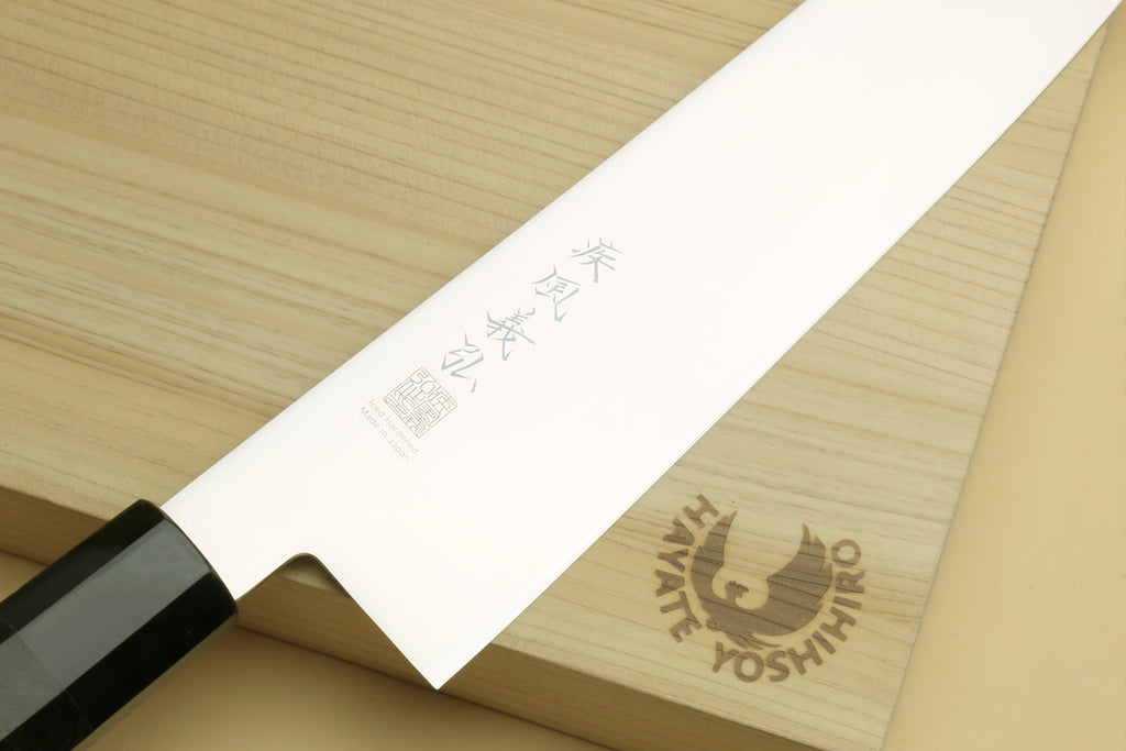 Japanese gyuto knife shown on blade face with engraved text and dark handle