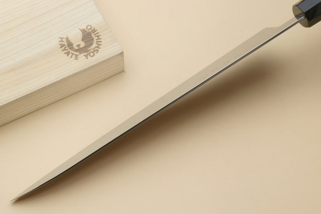 Chef knife side view with stainless edge and dark handle on wooden board