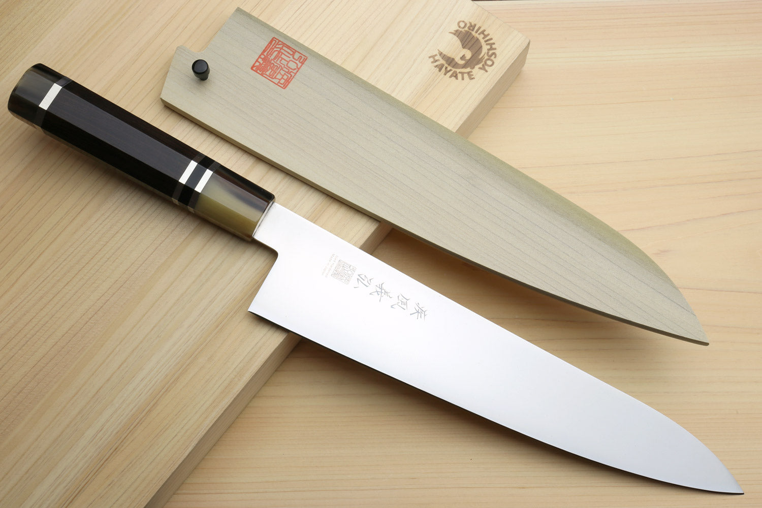 Japanese gyuto knife with stainless blade and dark octagonal handle, pointed tip