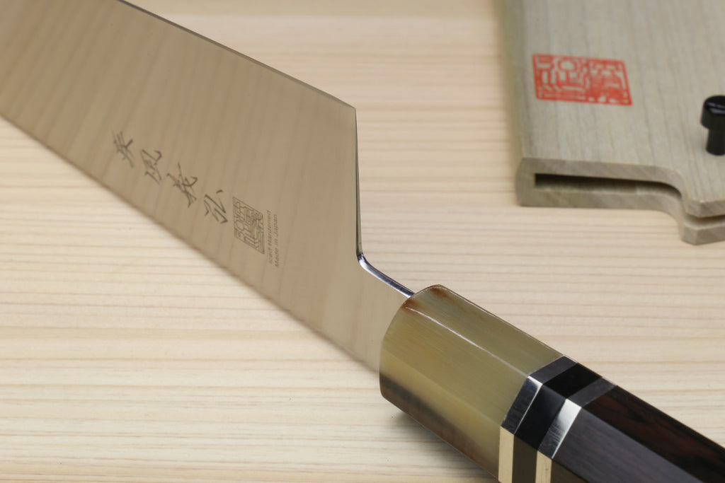 Japanese chef knife heel close-up with stamped blade and dark octagonal handle