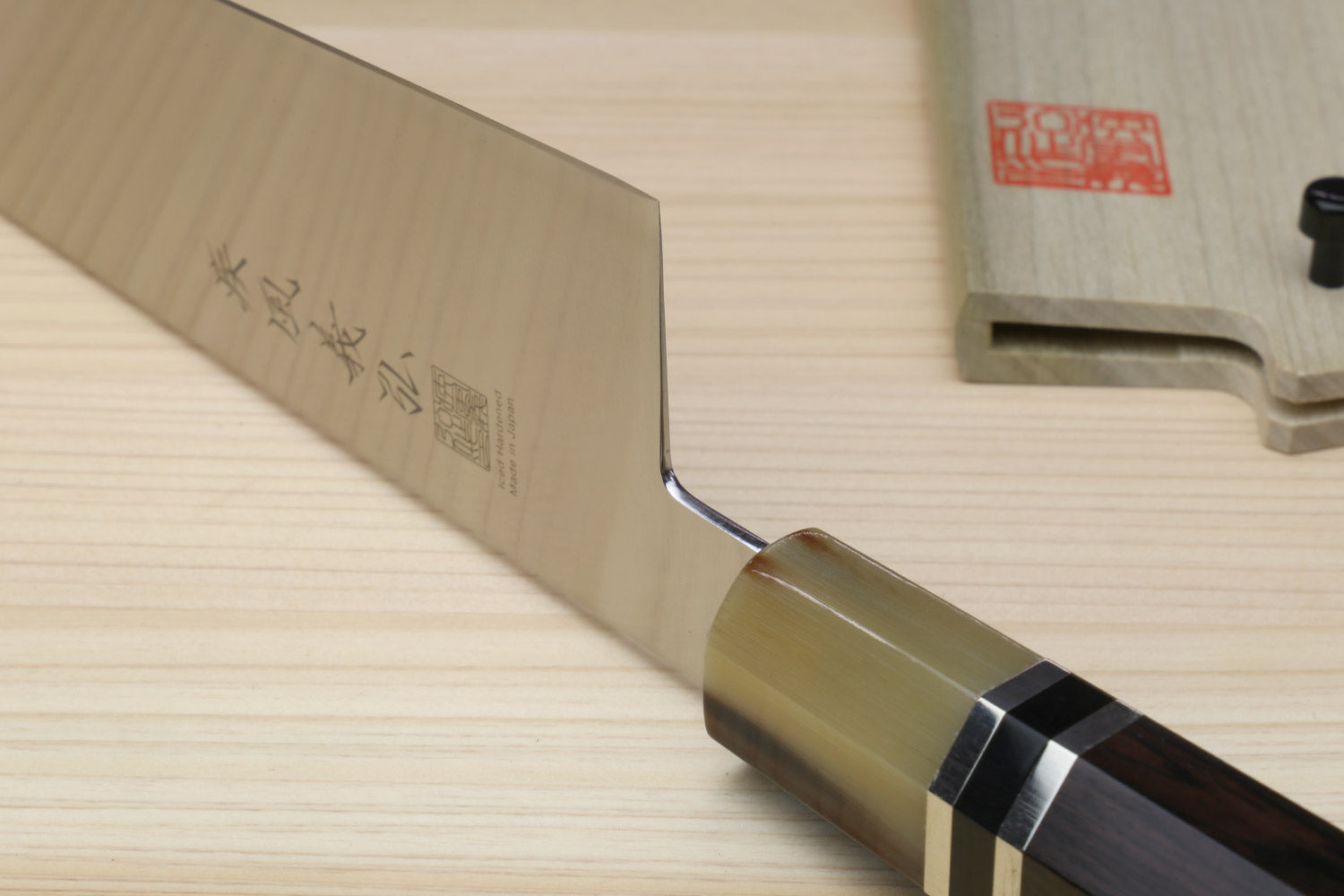 Japanese chef knife heel close-up with stamped blade and dark octagonal handle