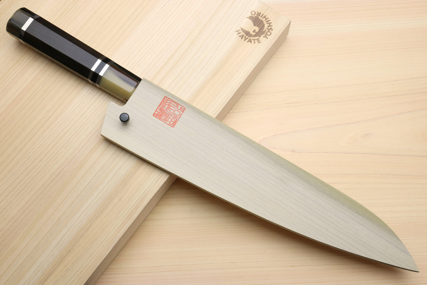 Japanese chef knife with stainless blade and dark octagonal handle with ring accents