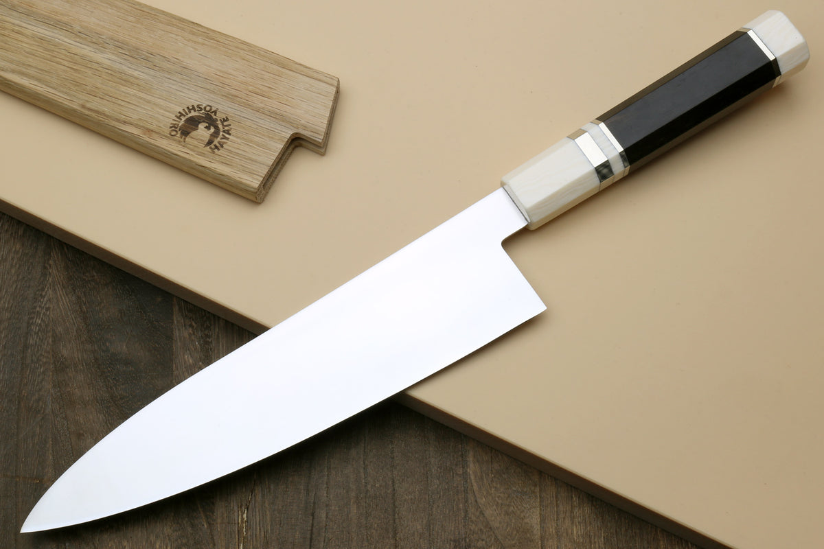 Japanese gyuto chef knife angled view, with ivory bolster and dark ebony handle