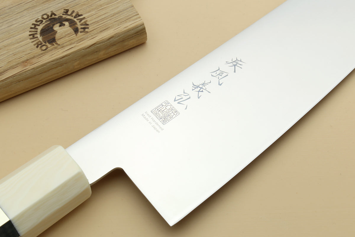 Japanese gyuto knife blade close-up with etched markings and ivory bolster