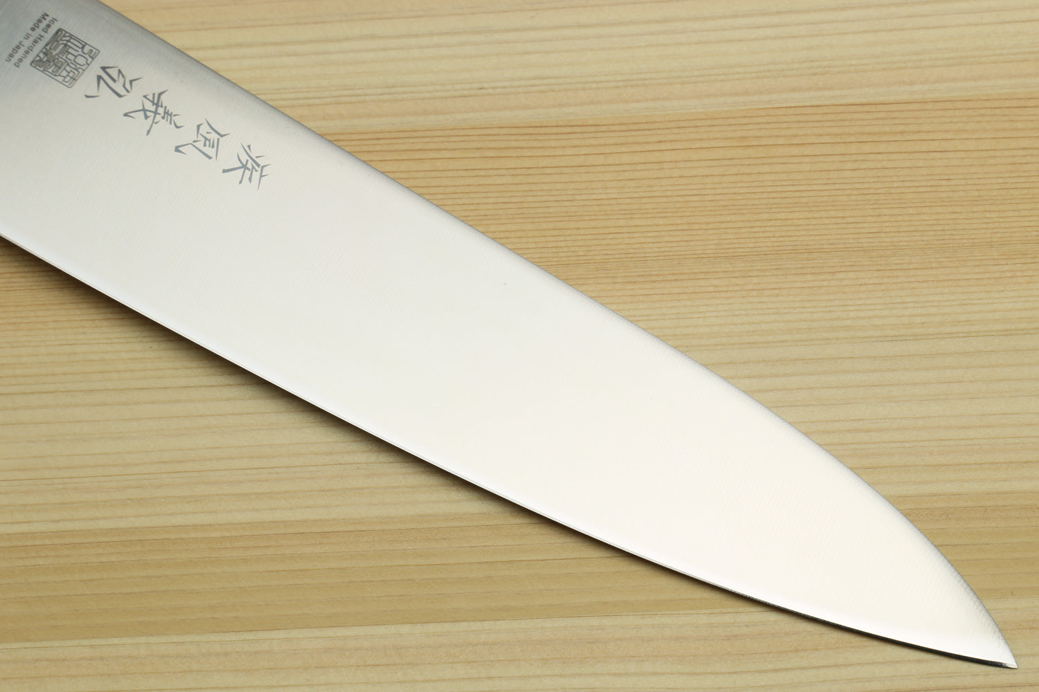 Stainless steel gyuto chef knife blade with etched markings, turquoise handle