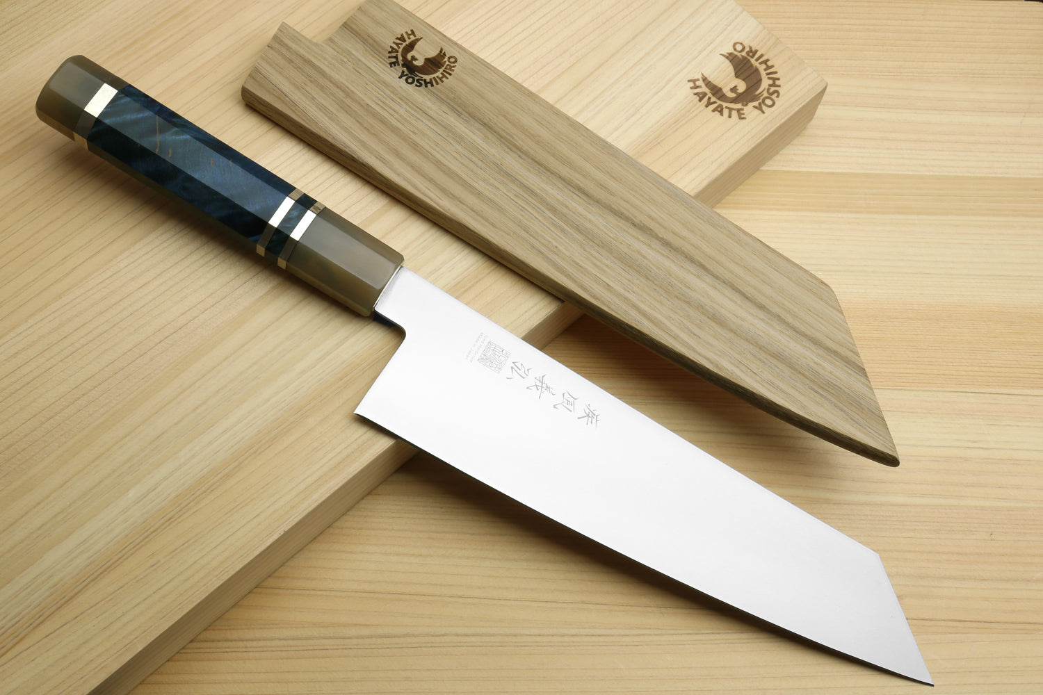 Kiritsuke chef knife with stainless blade and ocean blue handle beside wooden saya