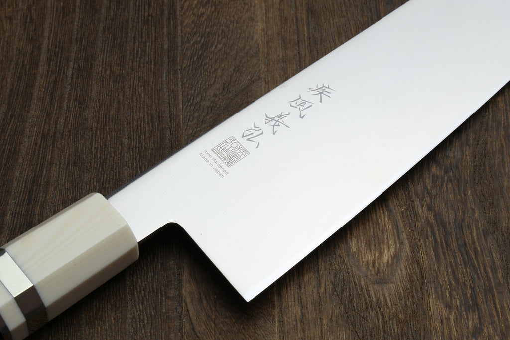 Kiritsuke chef knife blade with Japanese-style engraving on stainless steel.