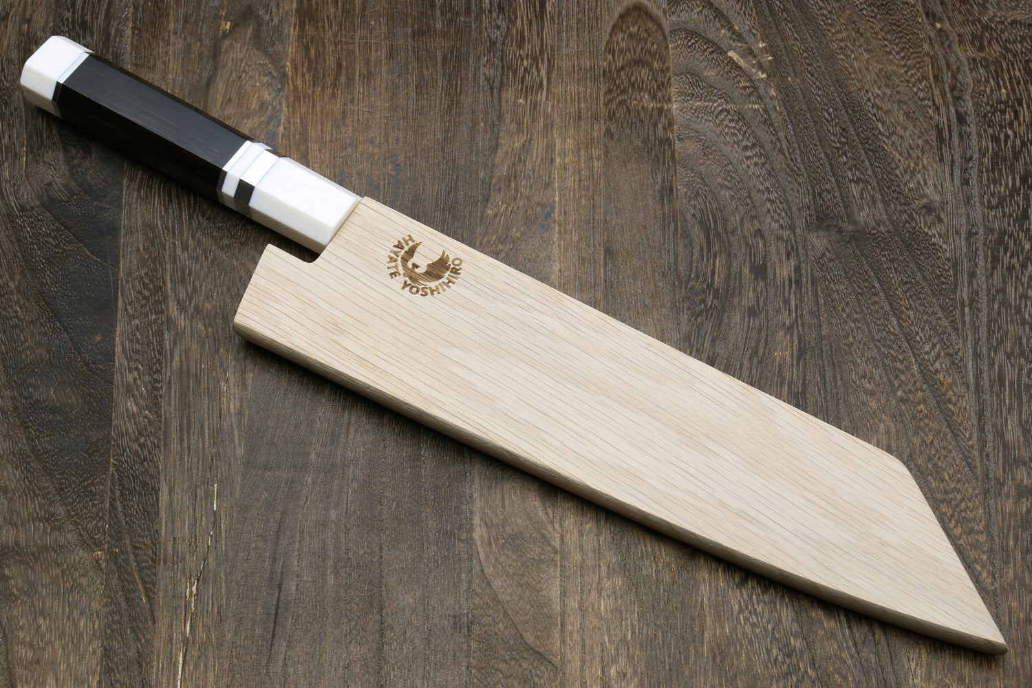 Kiritsuke chef knife with black handle and ivory bolster, with wooden saya.