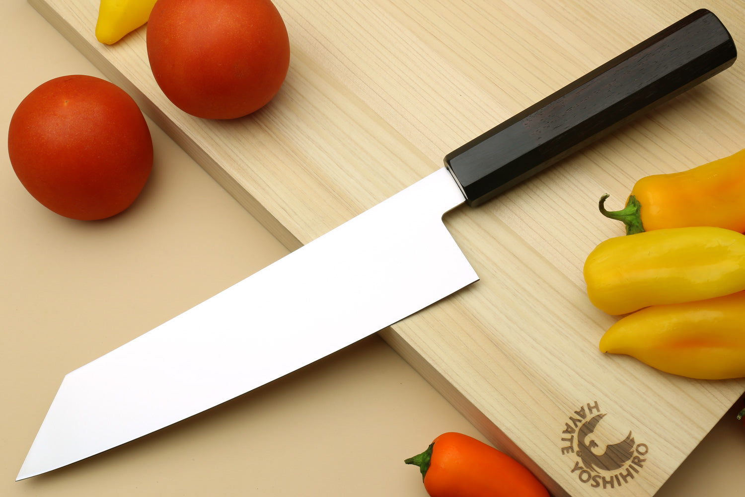 Kiritsuke chef knife with stainless blade and dark rosewood handle, angled view