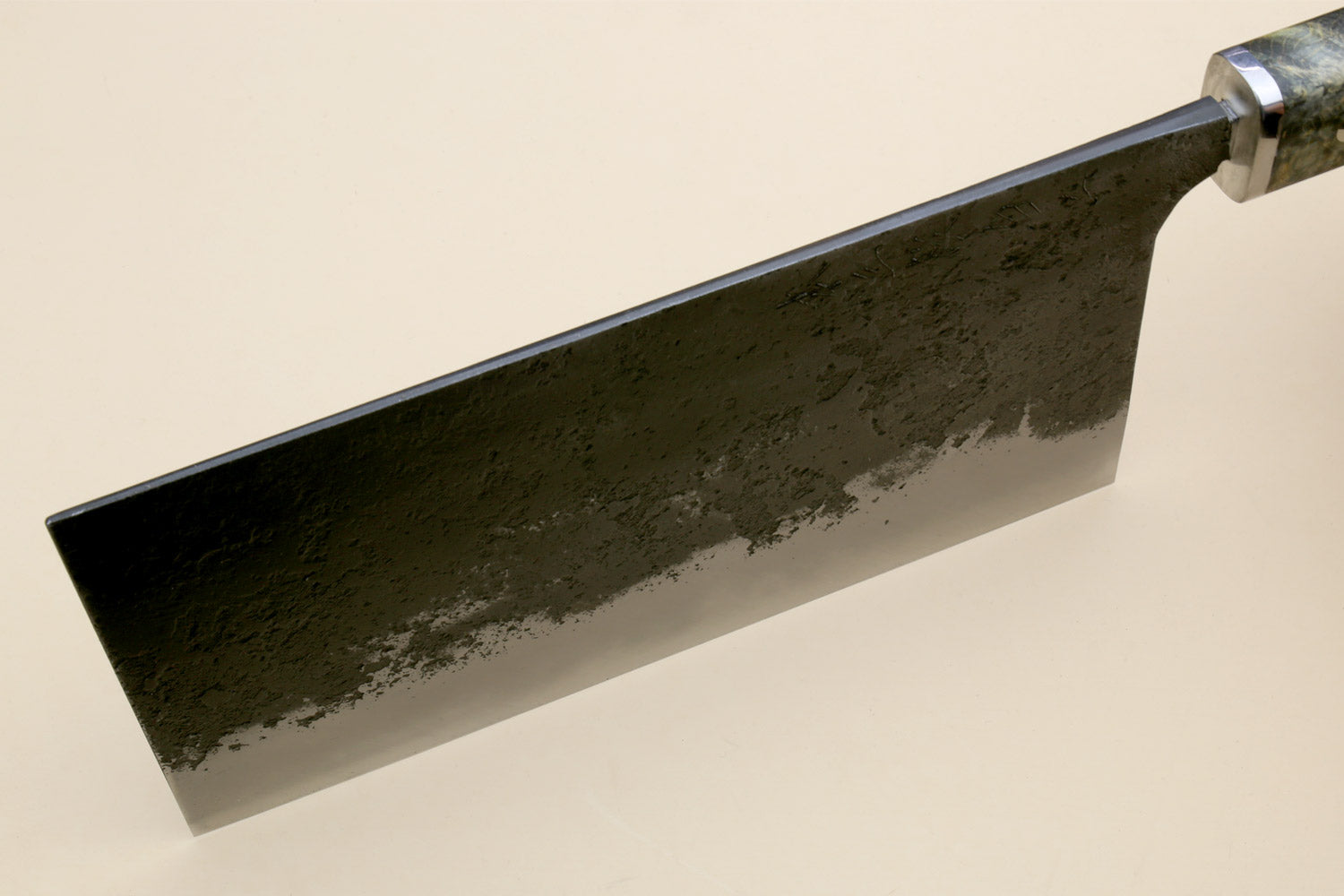 Chinese-style cleaver knife side view with dark speckled steel blade