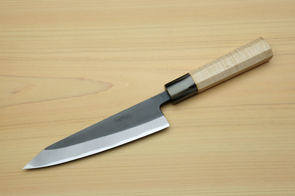 Kurouchi-finished blue steel petty knife with black bolster and light wood handle.