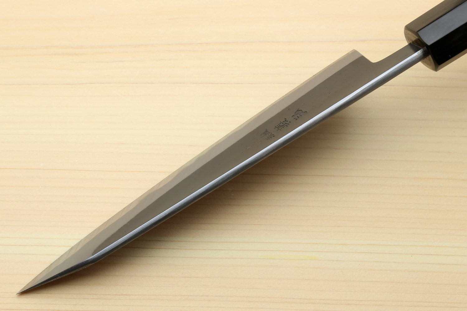Kurouchi-finished blue steel petty knife with light wood handle and black bolster.
