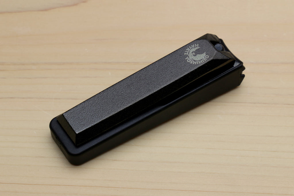 Black Japanese nail clipper with textured top and protective cover