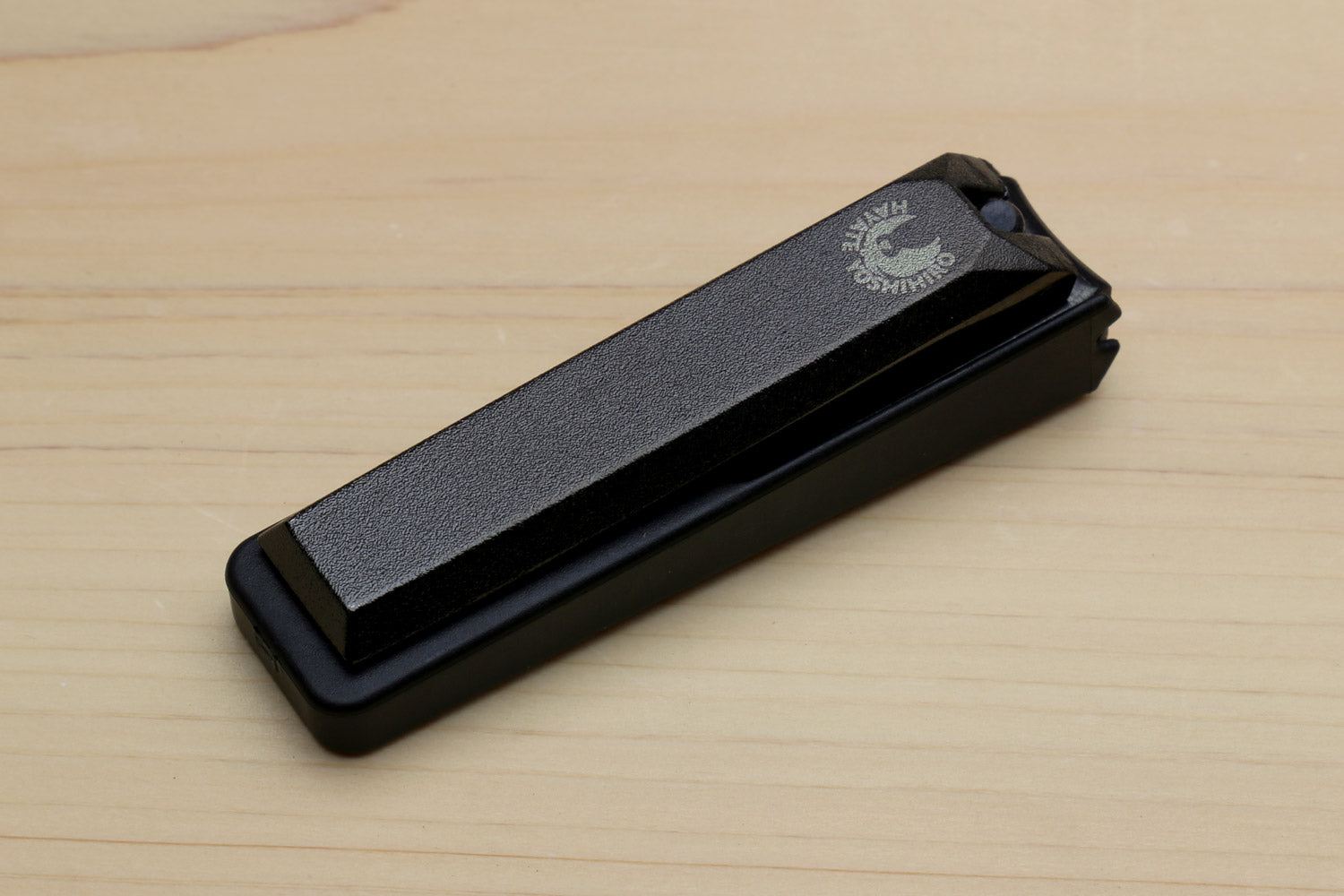 Black Japanese nail clipper with textured top and protective cover