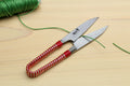Japanese sewing snip scissors with green thread and red string-wrapped handle