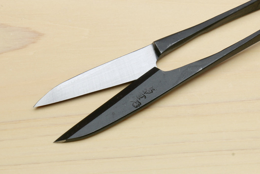 Japanese sewing snip scissors with silver blades and black handle, angled
