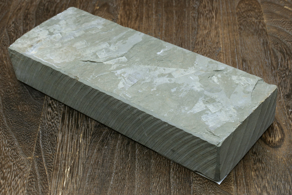 Natural sharpening whetstone, rectangular light gray stone with flat top and textured surface