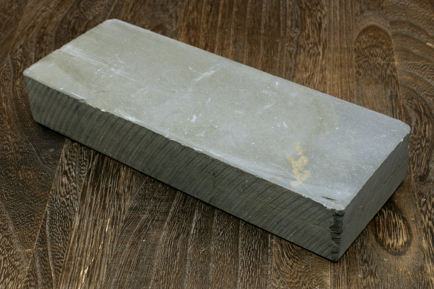 Natural sharpening whetstone block, pale white surface with dark side edge