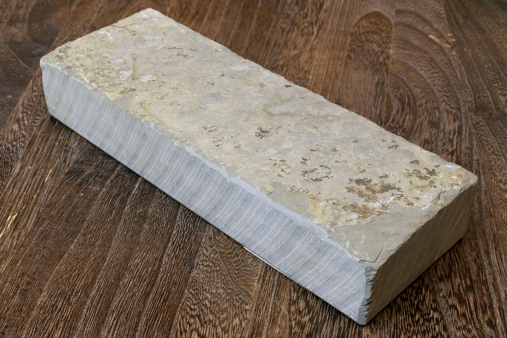 Natural sharpening whetstone block, off-white top with pale green speckled area and gray edges