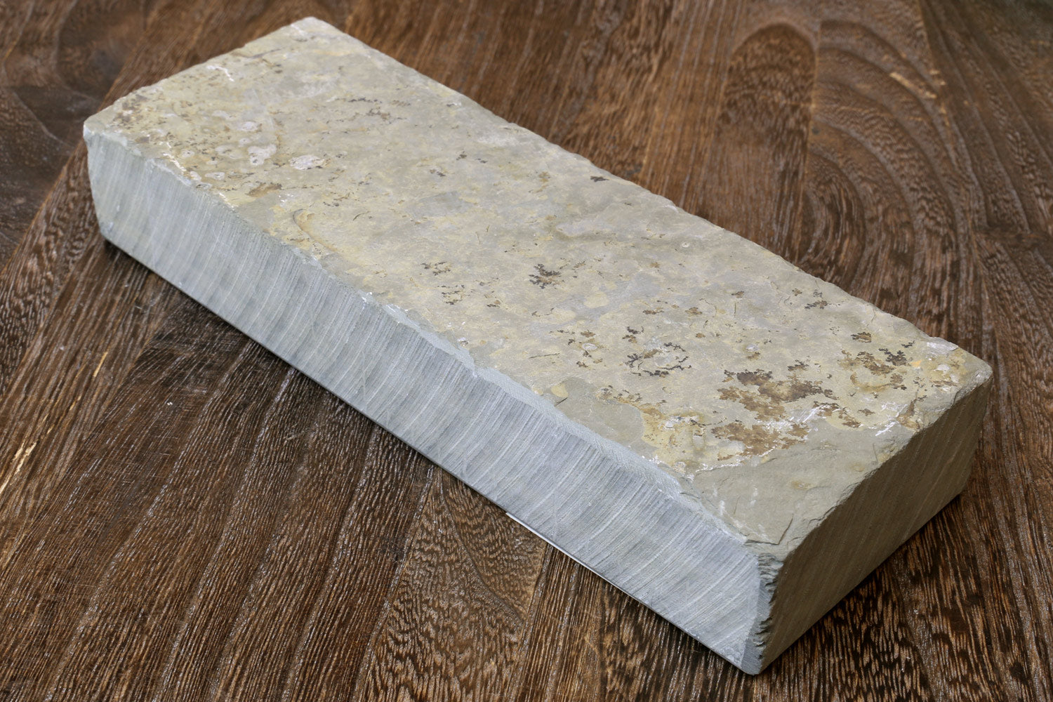 Natural sharpening whetstone block, off-white top with pale green speckled area and gray edges