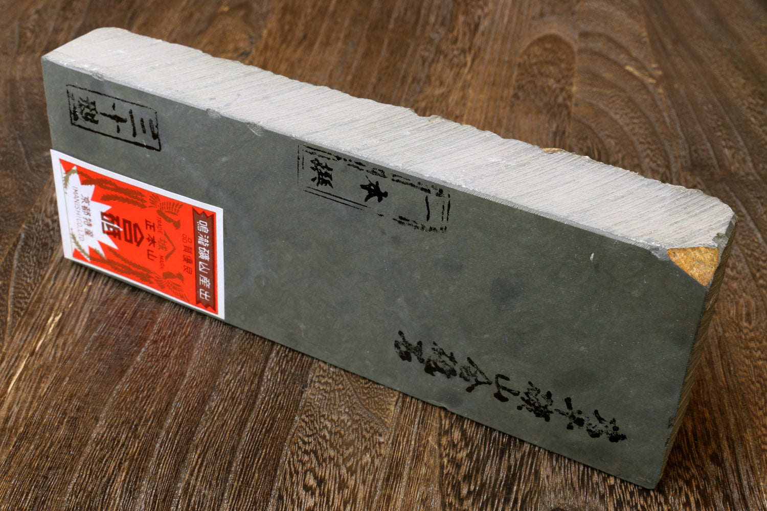 Sharpening whetstone, dark gray side with printed characters and red label on corner