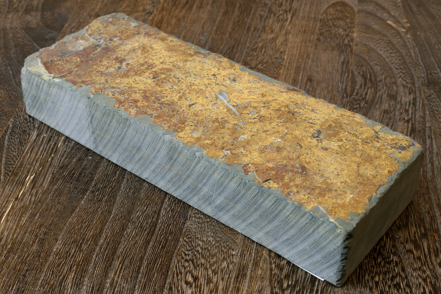 Natural whetstone block with yellow-brown speckled surface and gray edges