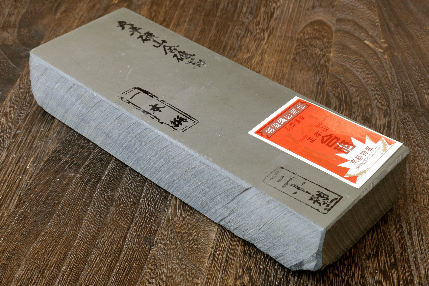 Rectangular natural sharpening whetstone, pale gray, with label on one end