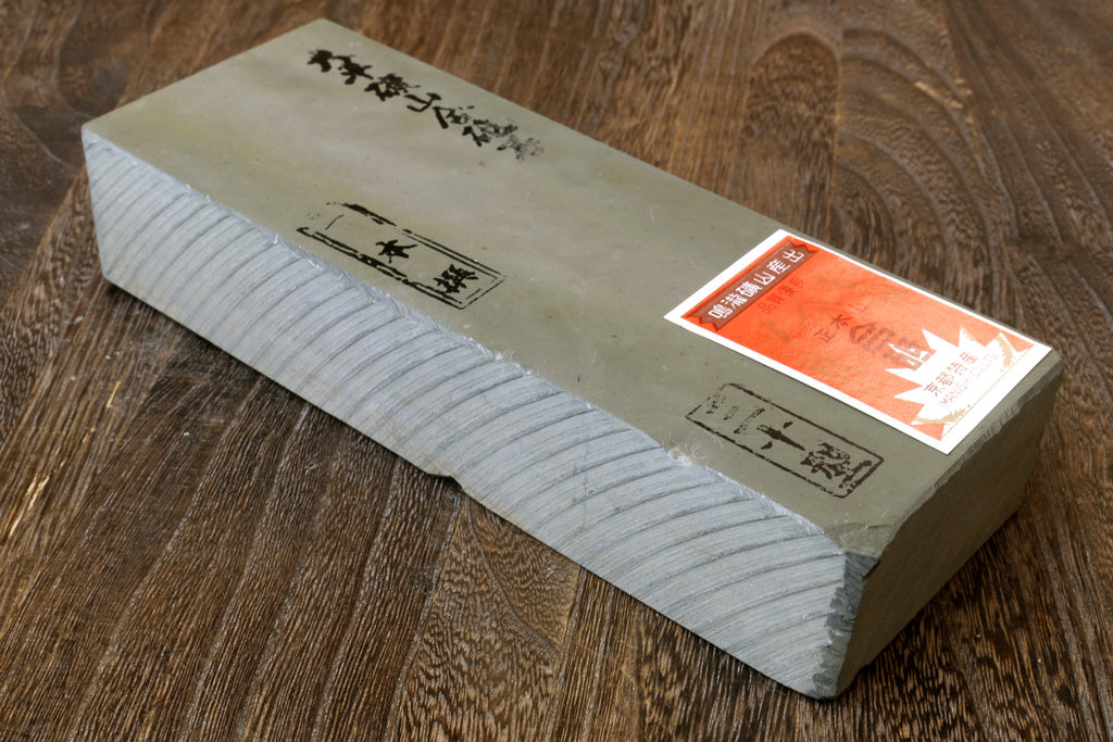 Natural sharpening whetstone with end labels, rectangular stone block