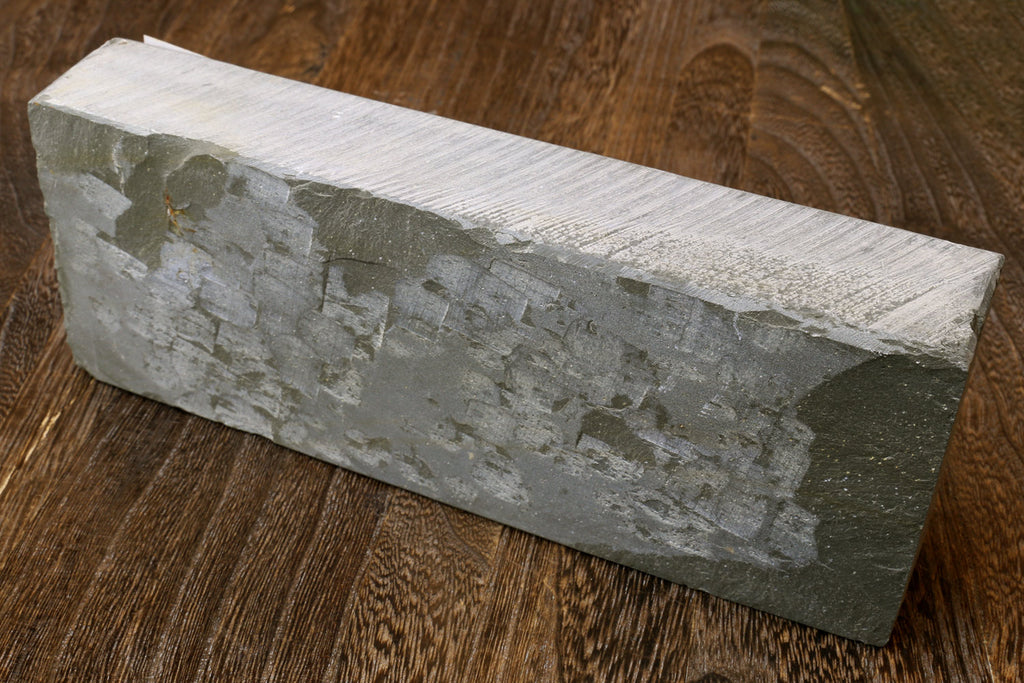Natural whetstone finishing stone, rectangular light gray block with rough surface texture