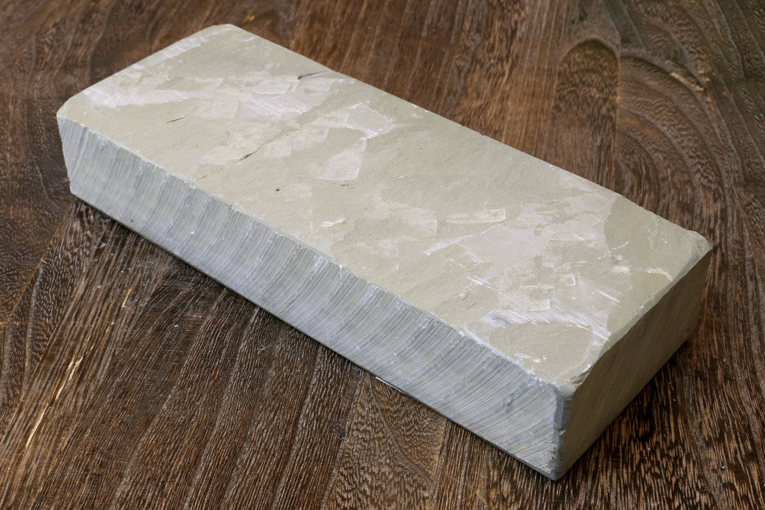 Natural sharpening whetstone block, pale gray stone with textured surface and flat edges