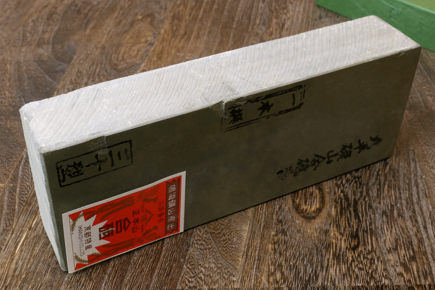 Natural sharpening whetstone, rectangular stone block with label stickers on the side