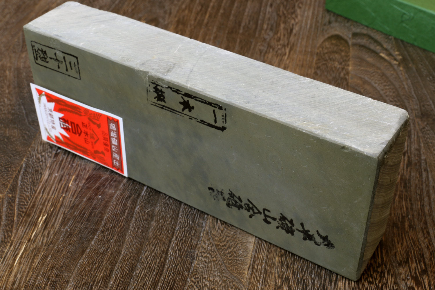 Natural sharpening whetstone, long light-gray stone block with printed text on side