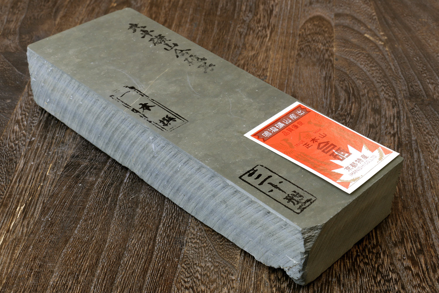 Rectangular gray whetstone sharpening stone with paper label on one face