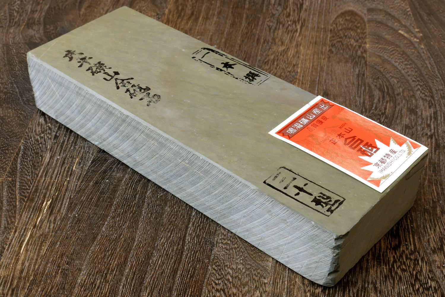 Natural sharpening whetstone block, pale gray with paper label on one end